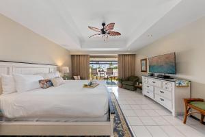 a bedroom with a large bed and a tv at Eldorado L202 · EL L202 Updated Condo with Beachfront Cabana in Kahana +42 photos
