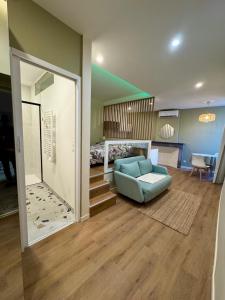 a living room with a blue couch and a bed at Demeure BelPel - Appartement Daurel in Bessan