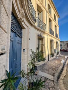 a building with a blue door on a street at Demeure BelPel - Appartement Daurel in Bessan +4 photos