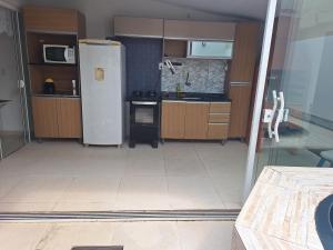 een keuken met een witte koelkast in de kamer bij Casa da Vo da Maria pertinho do mar in Matinhos