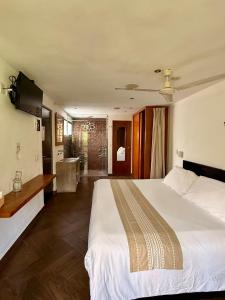 a bedroom with a large white bed and a bathroom at Mocca Hotels in Tepoztlán