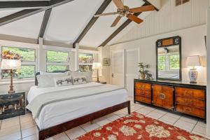 a bedroom with a large bed and a ceiling fan at International Colony Club 43 · ICC 43 Spacious 2BD Cottage Walk in Lahaina +47 photos
