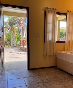 a door to a bedroom with a view of a yard at Pousada Samburá in Garopaba