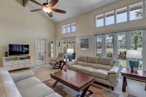 a living room with a couch and a tv at Belle Vue - Modern condo near beach w golf views in Ponte Vedra Beach