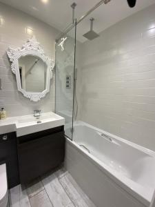 利明顿THE KNIGHTWOOD OAK a Luxury King Size Bed - En-Suite Space - LYMINGTON NEW FOREST with Totally Private Entrance - Key Box entry - Free Parking & Private Outdoor Seating Area - Town ,Shops , Pubs & Solent Way Walking Distance & Complimentary Breakfast的带浴缸、水槽和镜子的浴室 更多77张照片