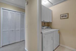a white laundry room with a sink and a washer at Belle Vue - Modern condo near beach w golf views in Ponte Vedra Beach +16 photos