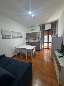 a living room with a table and a kitchen at Casa Tropea Vibes in Tropea