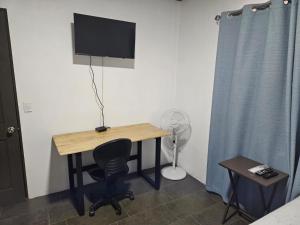 a room with a desk with a television and a chair at Paso de las Lapas in Uvita
