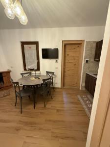 una sala da pranzo con tavolo, sedie e televisione di Rifugio di Peter a Castel di Sangro