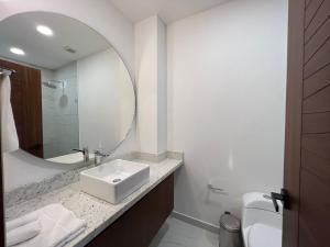 a white bathroom with a sink and a mirror at Place in the Romantic Zone with a Rooftop 301 in Puerto Vallarta