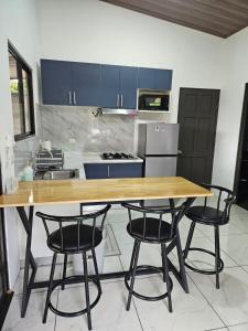 a kitchen with a wooden table and four chairs at Paso de las Lapas in Uvita