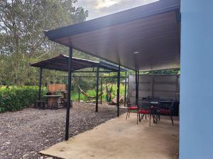 a pavilion with a table and chairs under it at Paso de las Lapas in Uvita