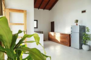 ein Wohnzimmer mit einem Kühlschrank und einer Pflanze in der Unterkunft Hotel Emanuel Kabalana in Piyadigama