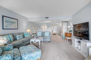 a living room with a couch and a tv at Beachy Vibes - 2BR w lake views & screened sunroom in Ponte Vedra Beach
