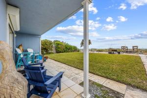 a porch with two blue chairs on a patio at Oceanview Escape Private Beach Access in South Cocoa Beach