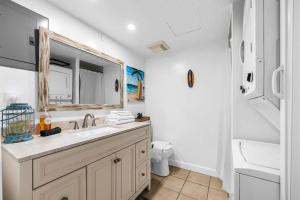 a bathroom with a sink and a mirror and a toilet at Oceanview Escape Private Beach Access in South Cocoa Beach +28 photos