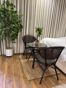 2 Stühle und ein Tisch in einem Zimmer mit Pflanzen in der Unterkunft Studio Apartments in Sulaymaniyah in Riad
