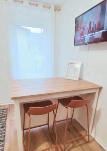 einen Schreibtisch mit zwei Stühlen und einem Laptop darauf in der Unterkunft Instant Emeraude Apartment in Saint-Brieuc