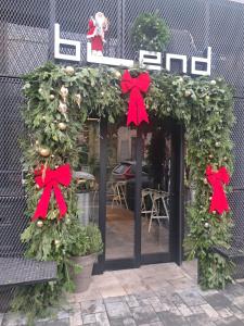 a store front with a christmas wreath and red bows at Aparthotel Blend City Center in Bucharest