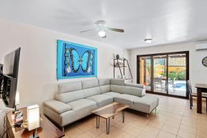 ein Wohnzimmer mit Sofa und Fernseher in der Unterkunft Charming Duplex in Playa Potrero Surfside Community, with a Private Pool, Cozy Interior and Walkable Access to the Beach in Potrero