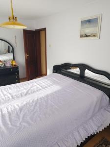 a bedroom with a white bed with a black frame at Вила Релакс in Pleven