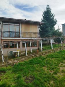 a house with a deck and a tree in front of it at Вила Релакс in Pleven