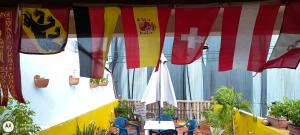 un patio con bandiere colorate, tavoli e sedie di Hostal Casa de las Americas a Cartagena de Indias