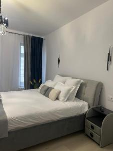 a bedroom with a large bed with white sheets and pillows at Uniri Urban Escape in Craiova
