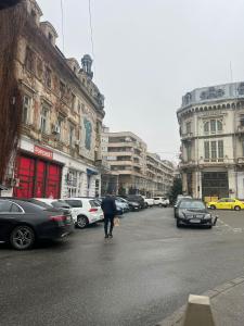 a person walking across a city street with cars at Uniri Urban Escape in Craiova