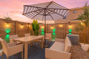 eine Terrasse mit Tisch und Stühlen und einem Sonnenschirm in der Unterkunft Gated community 4BD townhouse next to Disney in Kissimmee