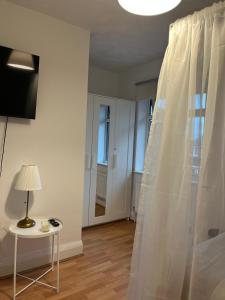 una camera da letto con tenda bianca e tavolo con lampada di The Cotton Mill Hideaway a Manchester