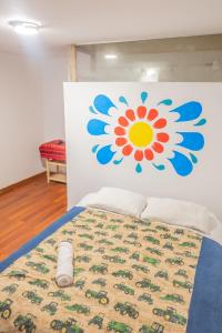 a bedroom with a bed with a flower on the wall at Carmen Alto Inn Charming Private Rooms Steps from Downtown in Cusco +1 photo