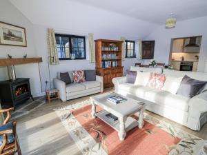 a living room with a couch and a table at Keepers Cottage in Warminster