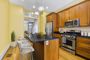 a kitchen with wooden cabinets and a black counter top at Premier 5BR Historic Victorian Townhouse in Washington +13 photos