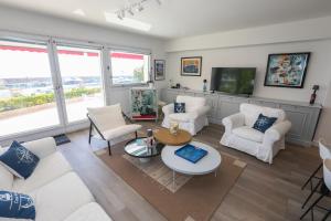 艾日Appartement exception les pieds dans l'eau的配有白色家具和平板电视的客厅