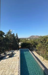 a swimming pool with turquoise water and rocks at Villa & Apartament Armonia 3 Gaja Flora Gavalochori - Vamos KRETA in Vamos
