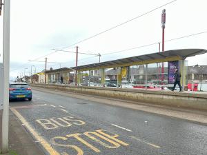 a blue car parked at a bus stop at The Cotton Mill Hideaway - One Bedroom Apartment - Free Parking near Etihad Stadium & CoOp Live in Manchester