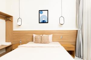 a bedroom with two beds and two lights at Hotel H4 Olanchito in Olanchito