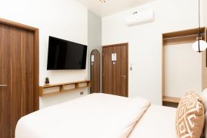 a bedroom with a bed and a flat screen tv at Hotel H4 Olanchito in Olanchito +16 photos