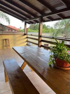 a wooden table with a potted plant on a porch at Pousada Samburá in Garopaba