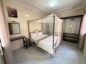 1 dormitorio con cama con dosel y espejo en Express at home, en Dakar