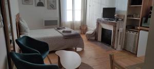 a bedroom with a bed and chairs and a television at Studio Amboise centre historique in Amboise