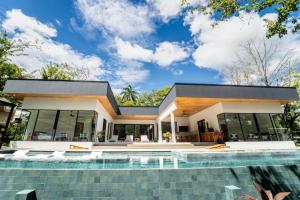 a house with a swimming pool in front of it at Casa McCash in Tamarindo