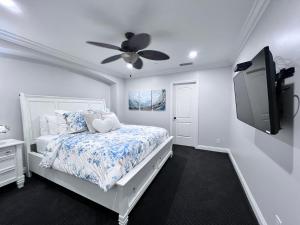 a bedroom with a bed with a ceiling fan and a tv at Destination #28 in Anaheim