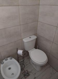 un bagno con un water bianco e un lavandino di Cabañas ohana a Camet Norte