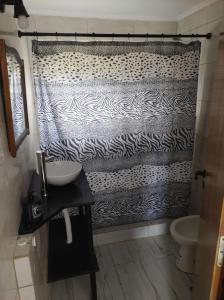 un bagno con una tenda da doccia con stampa zebrata di Cabañas ohana a Camet Norte Altre 2 foto