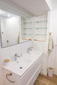 艾日Appartement exception les pieds dans l'eau的一间白色浴室，配有洗手池和镜子。