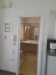 an open doorway to a bathroom with a sink at Anesis Premium Living Ιωάννινα in Ioannina