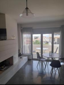 a living room with a table and chairs and a fireplace at Anesis Premium Living Ιωάννινα in Ioannina +5 photos