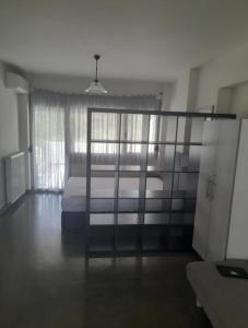 a bedroom with a bed and a large window at Anesis Premium Living Ιωάννινα in Ioannina